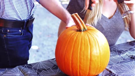 man carving a pumpkin to make halloween lantern