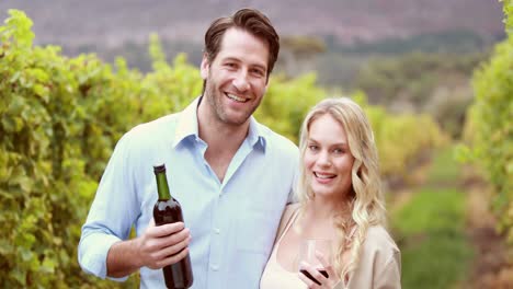 Happy-couple-holding-a-red-wine-bottle-and-glass