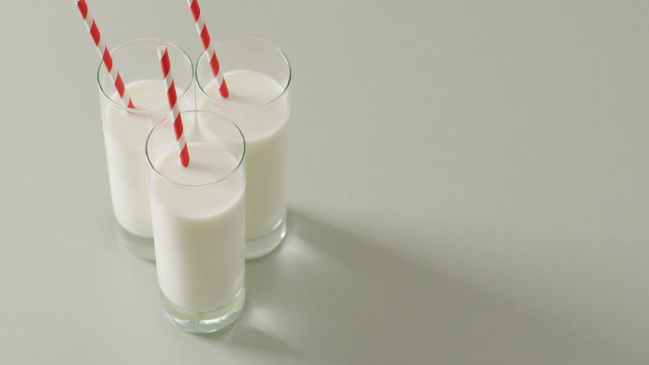 видео с тремя стаканами молока на белом фоне