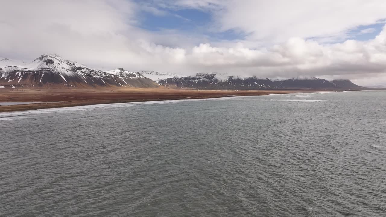 Snow-capped mountains and coastal landscape near Búðir on the Snæfellsnes Peninsula, Iceland.