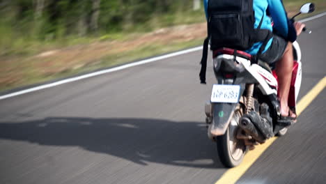 tourist riding a motorcycle on a open road in asia