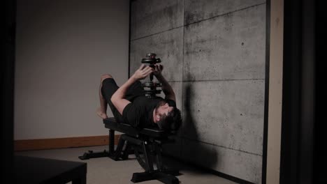 Lying-dumbbell-tricep-extension,-cinematic-lighting,-white-man-dressed-in-black-gym-attire