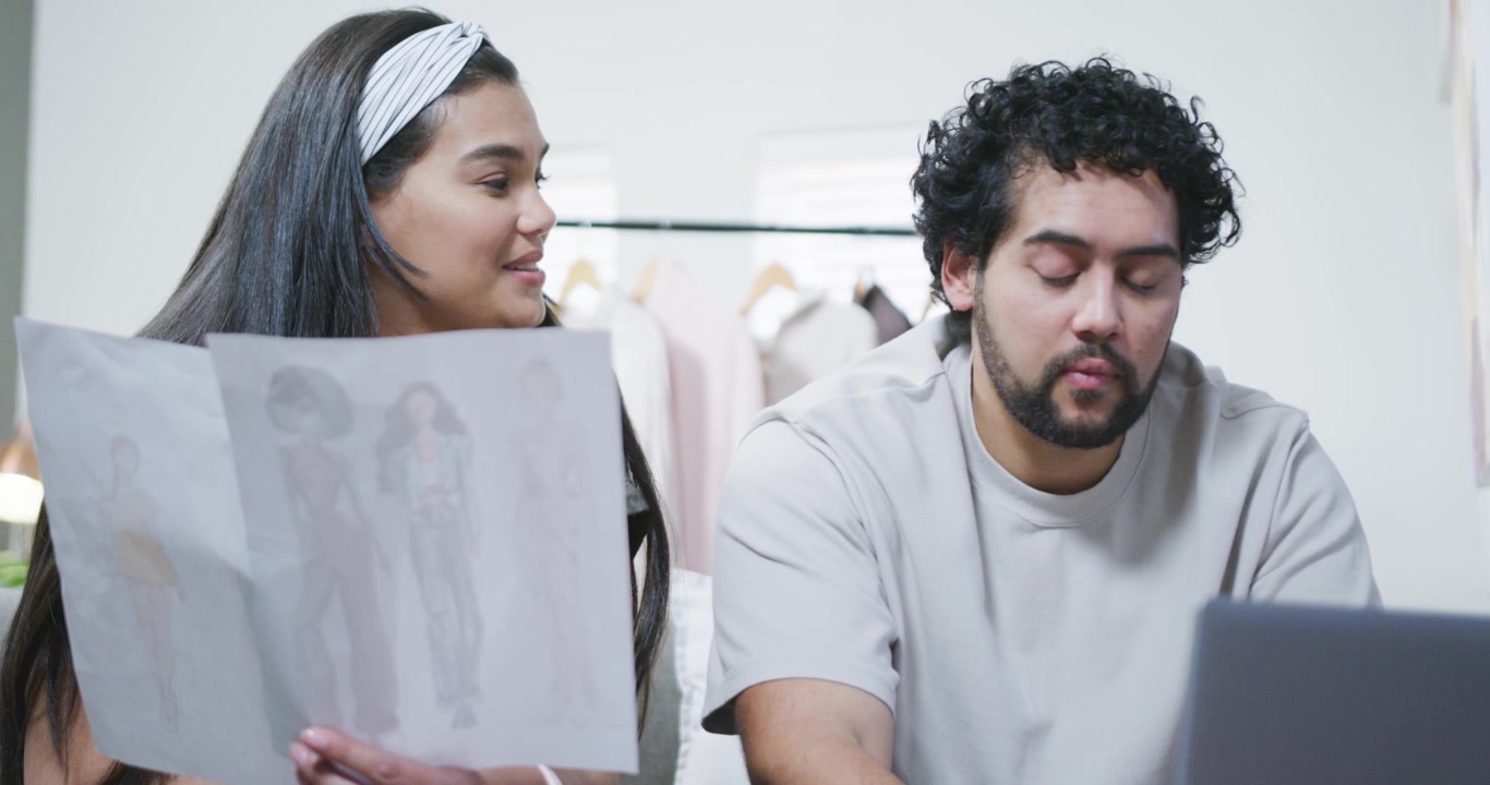 Diseñadores de moda colaborando en bocetos de ropa en estudio