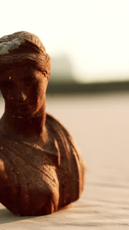 close up of a rusty stone statue of a woman