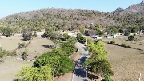 Aerial-shot-of-beautiful-village-and-a-concrete-road-passing-from-the-middle-of-the-village-in-Charu,-Chatra,-Jharkhand,-India