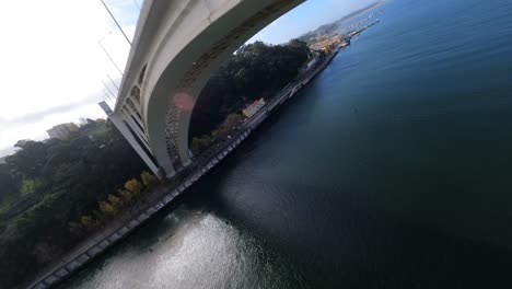 fpv drone crazy aerial flying under arrabida bridge over water porto portugal