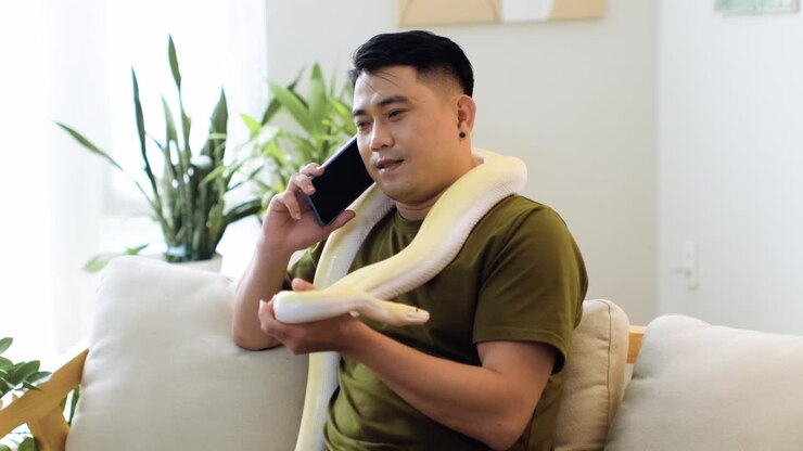 Man with snake talking on the phone