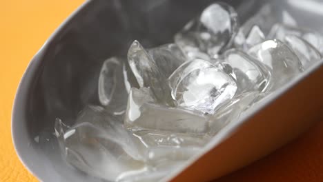 primer plano de cubos de hielo en un cubo gris