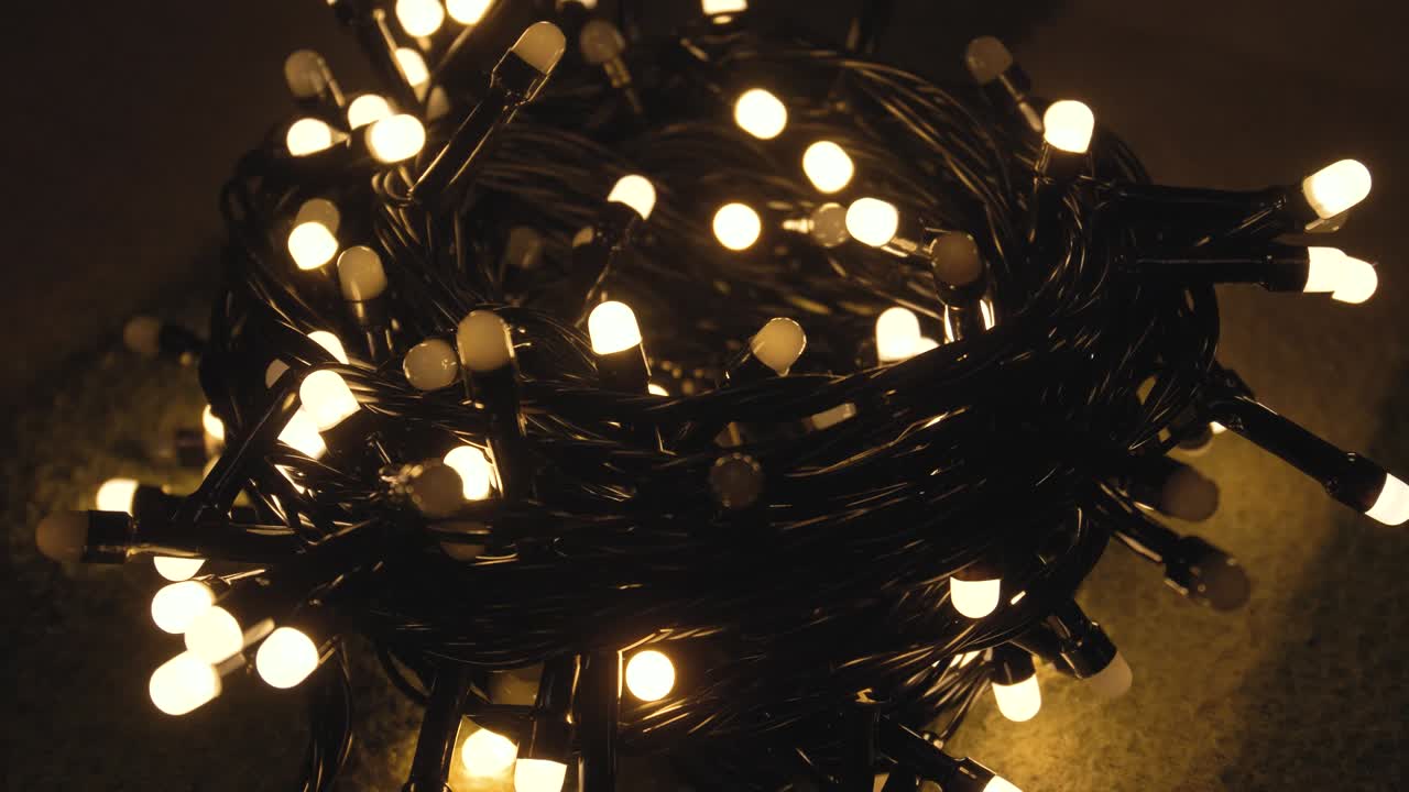 Close-up shot hank of christmas garland with golden lights on a playd. Christmas concept. Home decor