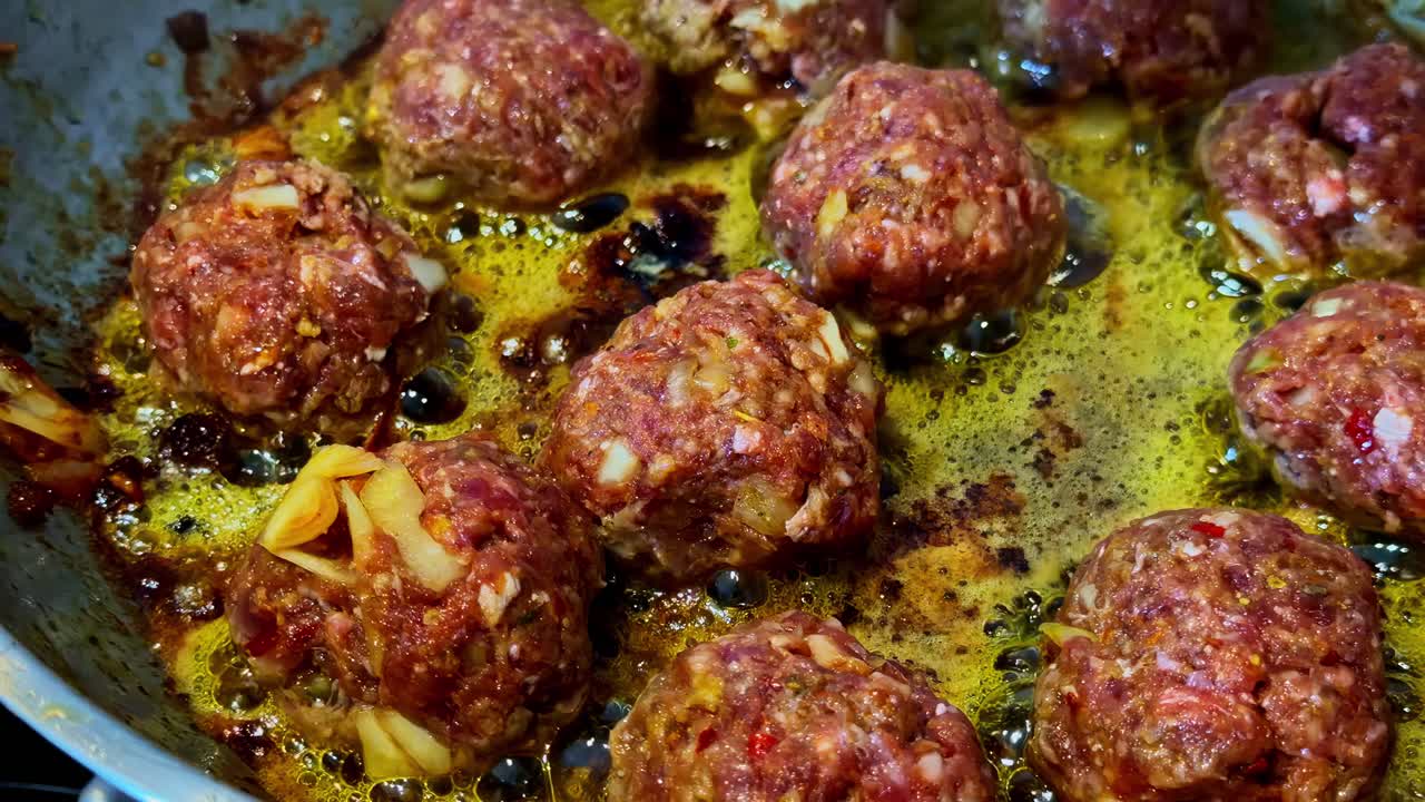 Baharatlarla birlikte tavada kızaran köftelerle lezzetli bir yemek hazırlığı