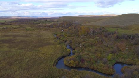 aerial view of a river winding through a forest in autumn