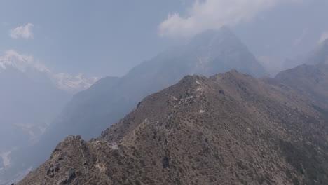 aerial view of trekking paths winding through high hills of sagarmatha national park, clouds cover horizons, cinematic natural scene in himalayas