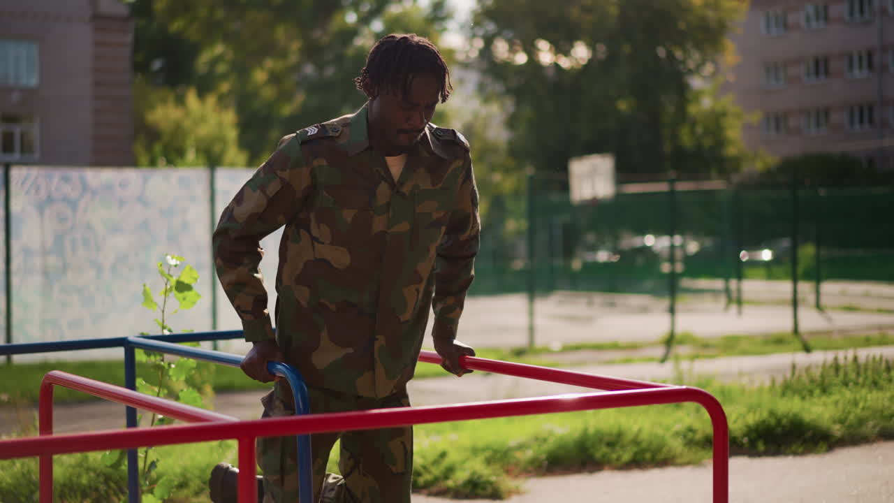 Black Soldier Performing Dips On Playground Rails, Focused Training Session In Urban Park, Camouflage Uniform, Controlled Movement, Sunlit Concrete, Athletic Determination And Steady Discipline