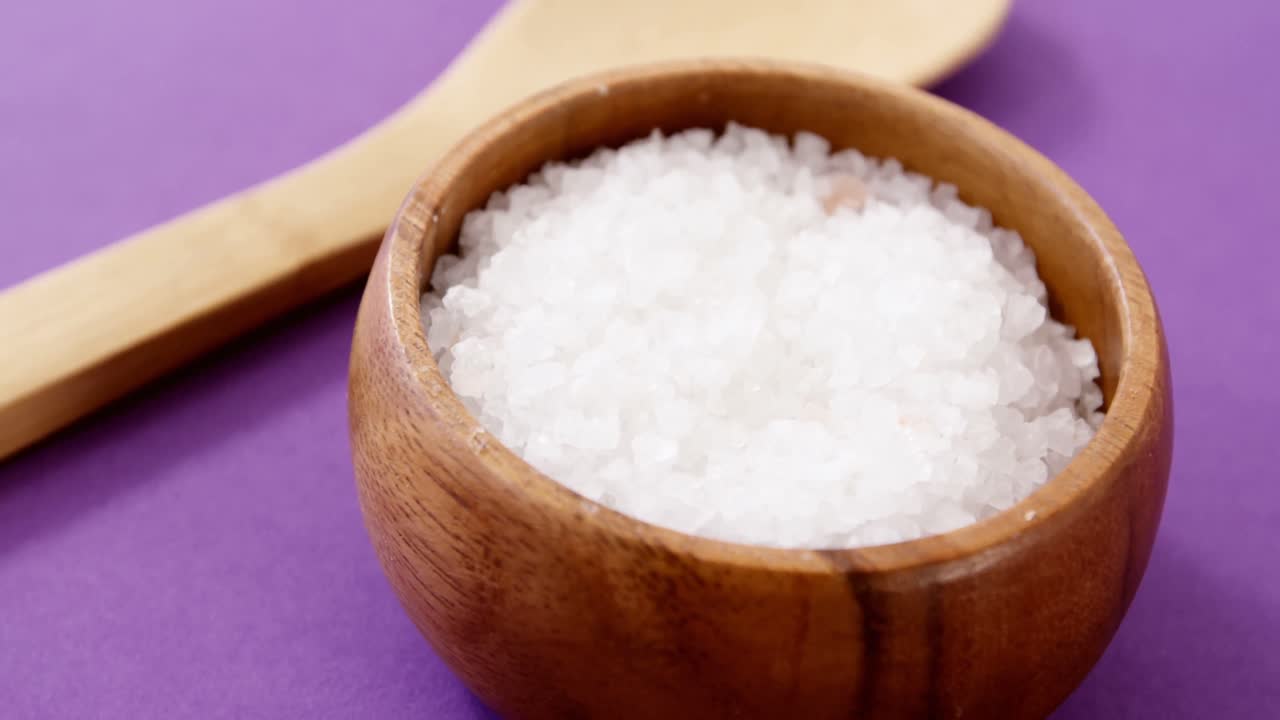 Sea salt in wooden bowl and wooden spoon