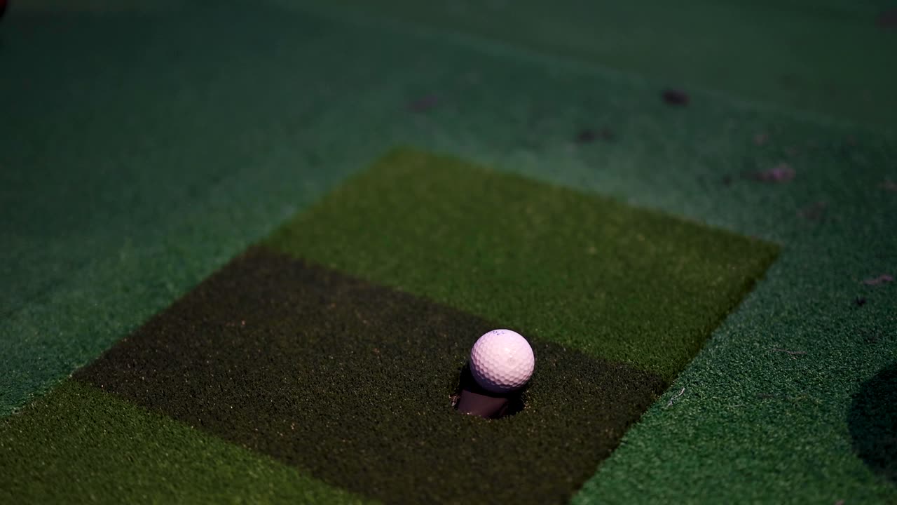 una pelota de golf moviéndose más cerca de la copa en el verde.