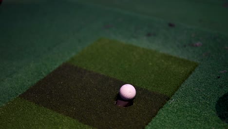 a golf ball moving closer to the cup on green.