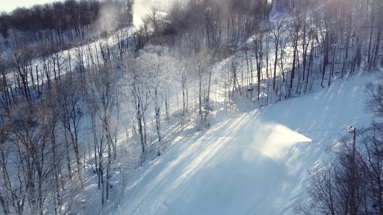 Snowy forest landscape with ski slopes and snow cannons in St-Sauveur, Québec, Canada