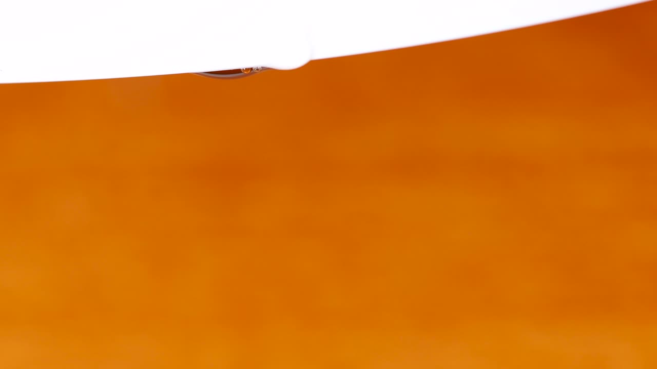 매크로 샷:흰색 테두리에서 나무 표면으로 떨어지는 물방울, 물방울에 날카로운 초점