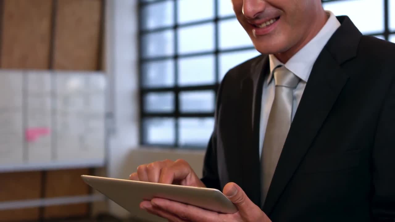 Smilende forretningsmand bruger tablet