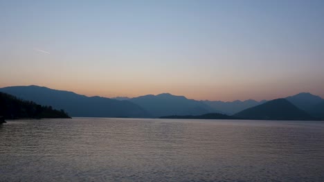 Vista-Del-Lago-Con-Montañas-En-Italia-Al-Atardecer