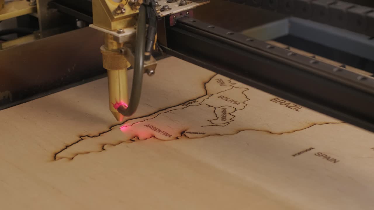 la máquina de corte por láser cnc corta el mapa del mundo en tabla de madera y contrachapado