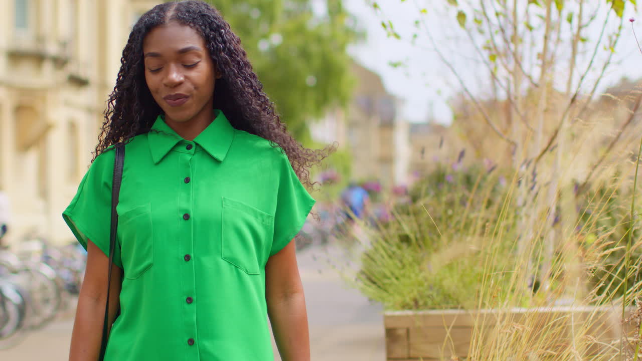 retrato de una turista sonriente de vacaciones en oxford, reino unido, explorando la ciudad caminando por broad street.