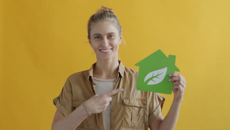 woman holding eco-friendly house sign