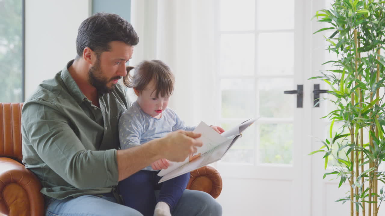 padre con síndrome de down hija leyendo un libro en casa juntos