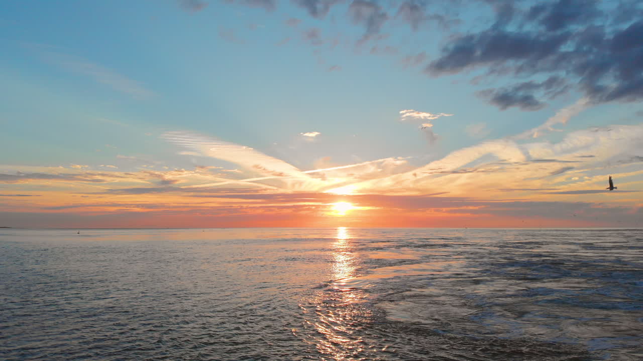 일몰 동안 네덜란드 남서부의 폭풍해일 방벽 근처 해변에서 잔잔한 썰물