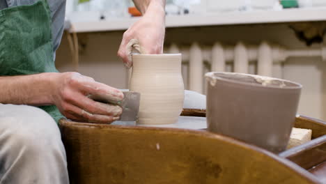 hands of a clerk modeling una ceramic piece on a potter wheel in a workshop