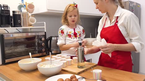 mother and daughter baking cupcakes together