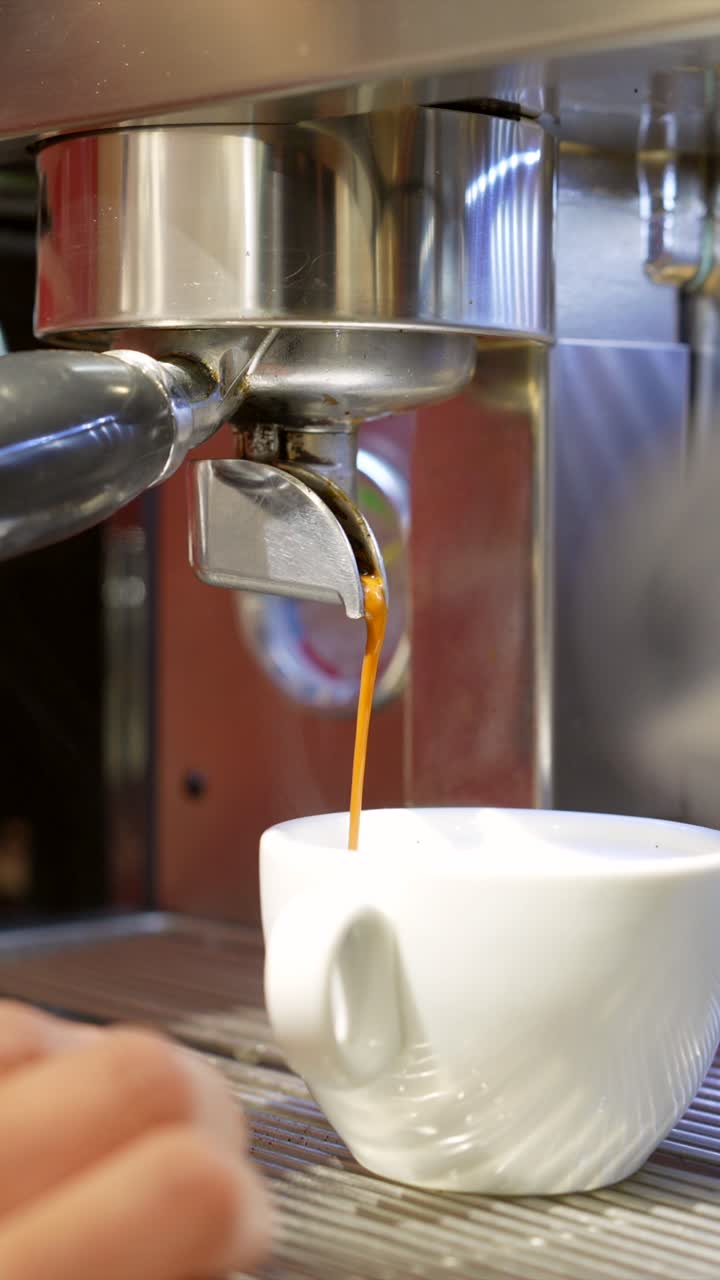 Primo piano di una macchina da caffè espresso che eroga caffè in una tazza.