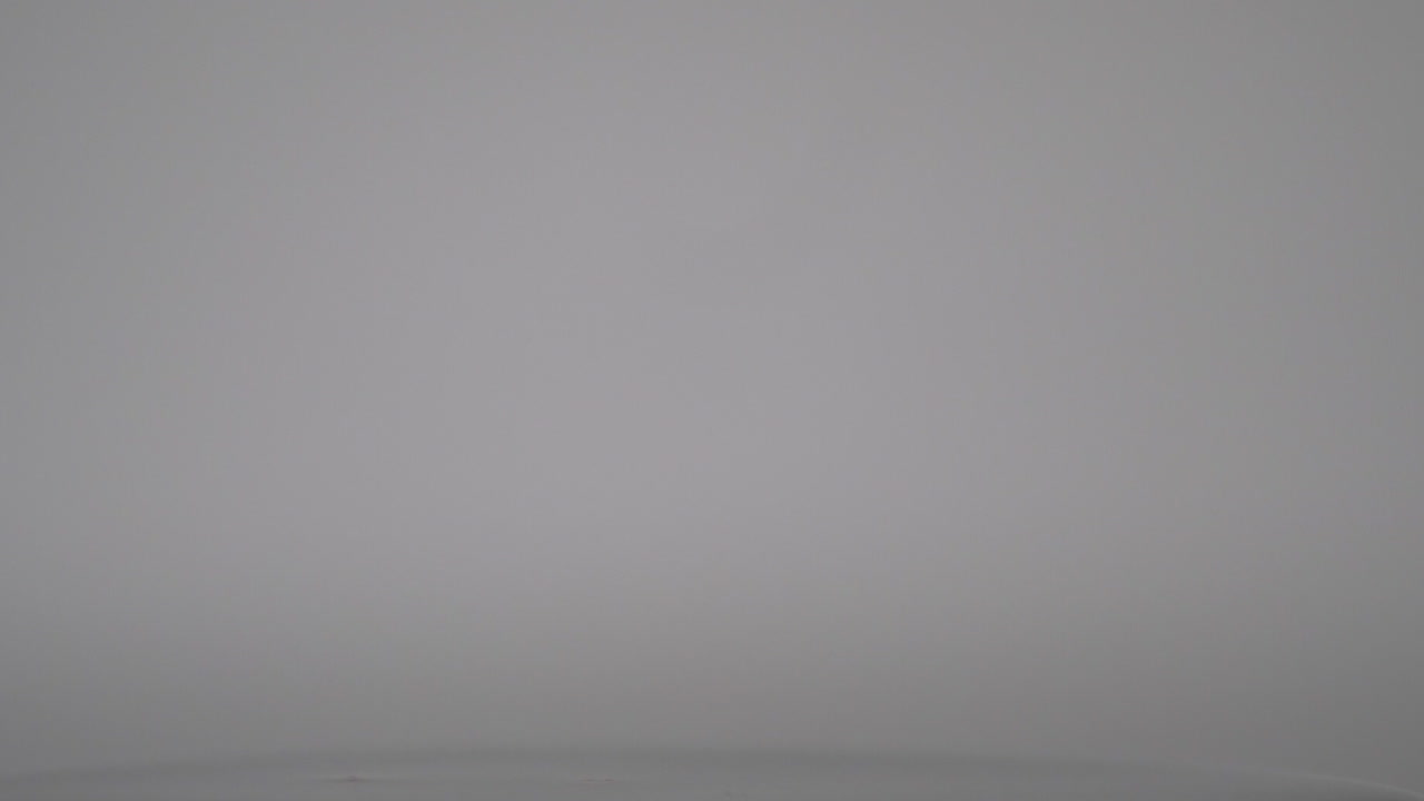 Orange Water Droplets Falling On The Water Surface Isolated In White Background. - close up shot