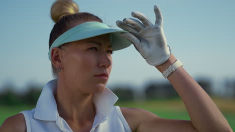 Jugador-De-Golf-Deportivo-Se-Encuentra-En-El-Campo-Verde.-Mujer-Seria-Mira-Lejos-Afuera.