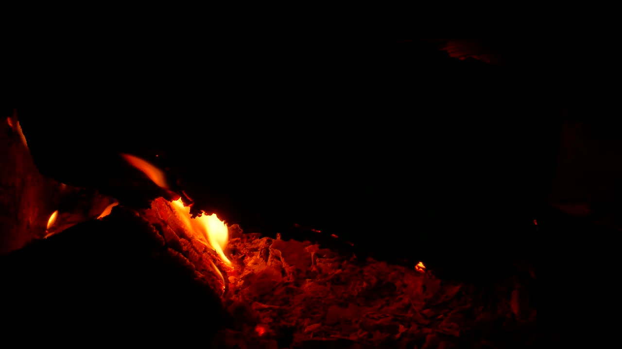 llama de estufa de madera fuego en la oscuridad. leña ardiente. llama de fuego. horno rural. chimenea ardiente. fogata turística por la noche. combustión de madera. emergencia. riesgo de ignición. humo al quemar.