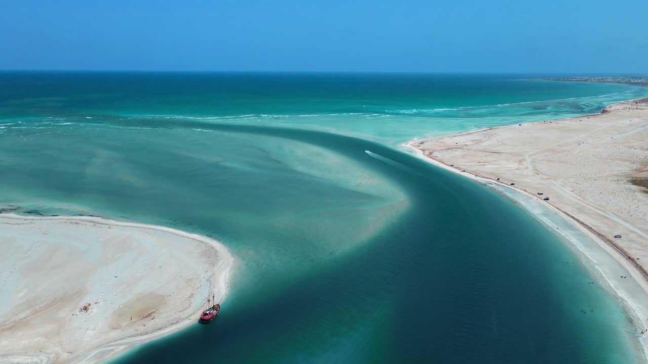 Et luftfoto af strandscenen ved Hassi El Jerbi med mennesker og både i vandet ved Zarzis, Tunesien.