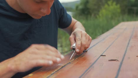 Junger-Mann-Schneidet-Altes-Holz-Mit-Messer-Und-Wartung-Von-Holzbooten