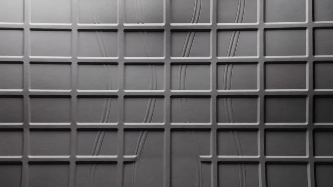 Bulging matte-gray seamed grid panel deforming in studio as rounded bulge pushing through center
