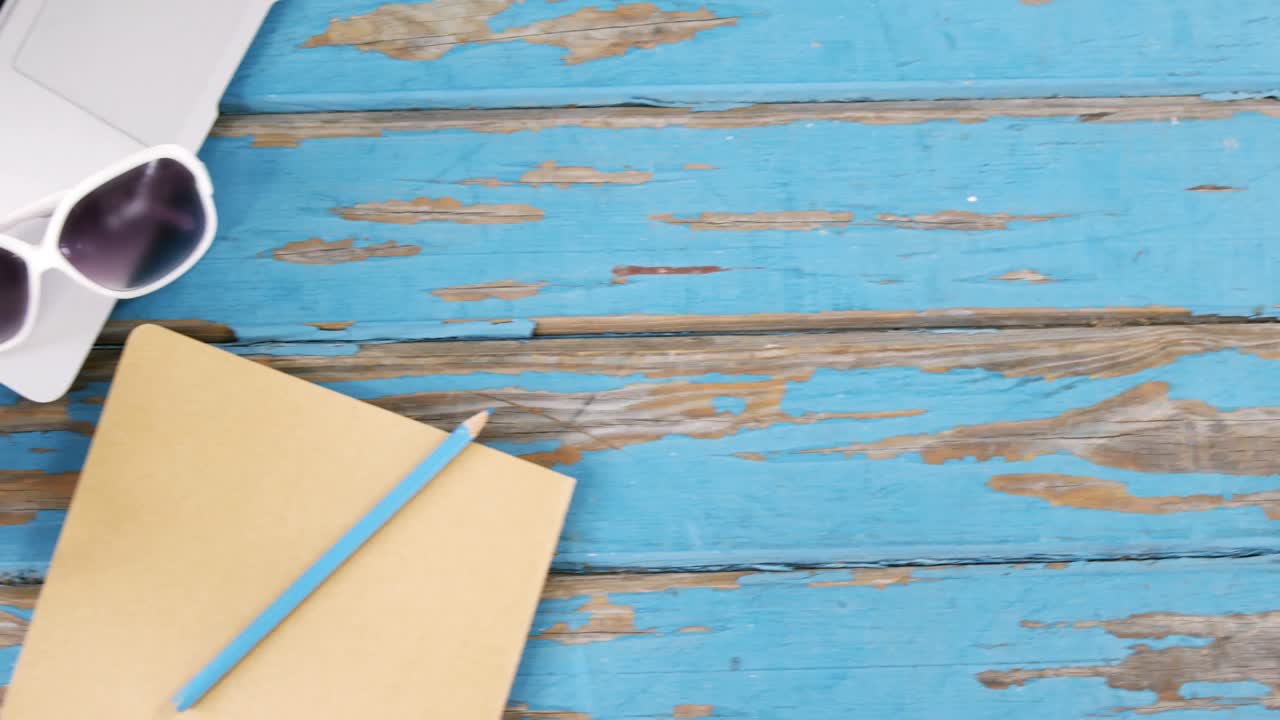 Portatile, occhiali da sole, agenda con matita e tazza di caffè