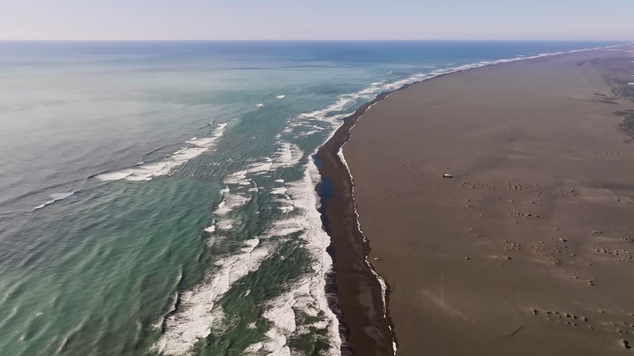 interminable playa de arena marrón y el océano en islandia, dolly aéreo en, paisaje vacío