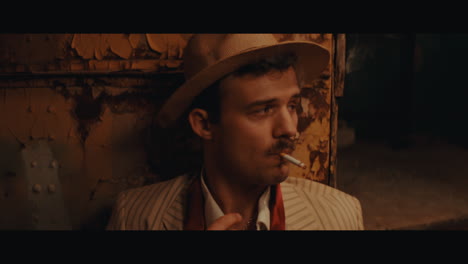 a man in hat smokes a cigarette in the circus camp