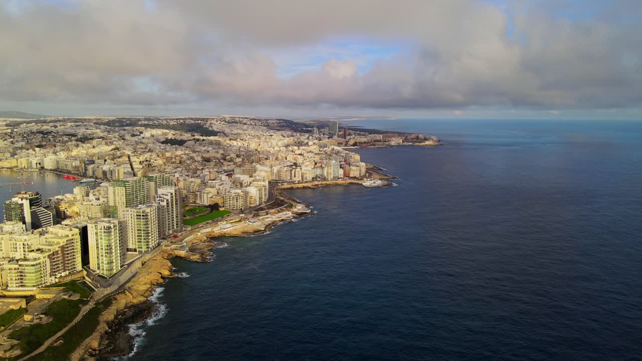 Vista aerea con drone della costa di Sliema che conduce alla baia di St Julian, con edifici urbani e il Mar Mediterraneo a Malta