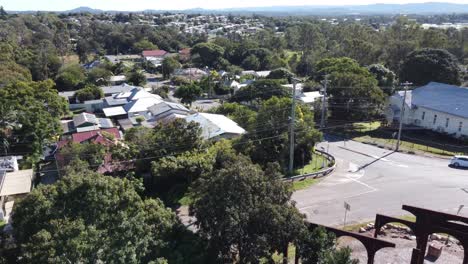 drone descending into a park showing private residential area and local streets with cars passing by