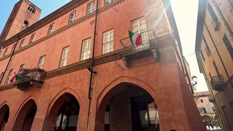 red brick building with arches and flags