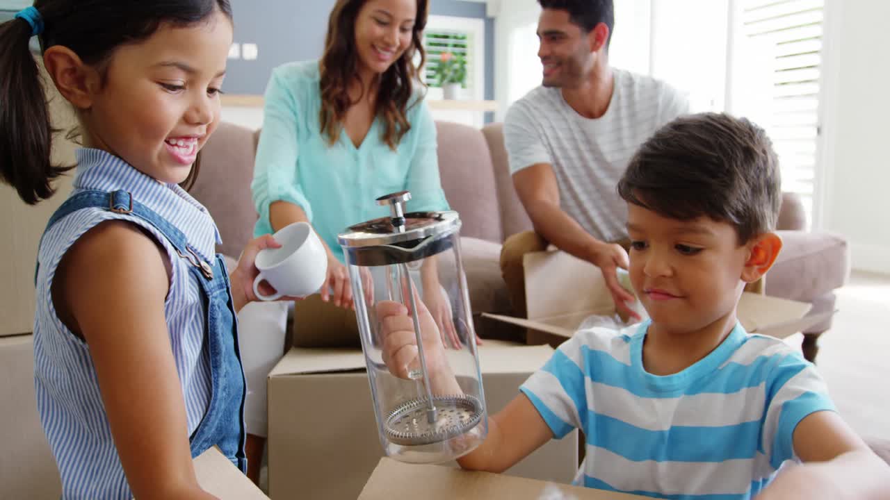 행복 한 가족 이 카드보드 상자 를 풀고 있다