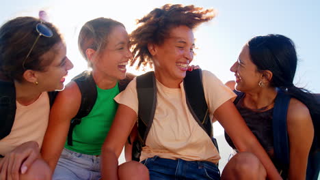 Portrait-Of-Female-Friends-With-Backpacks-On-Vacation-Taking-A-Break-On-Hike-Through-Countryside