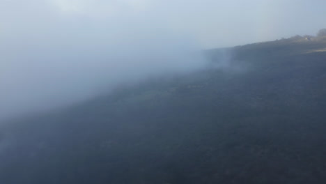 Aerial-dolly-through-misty-clouds-rising-above-tropical-island-slopes