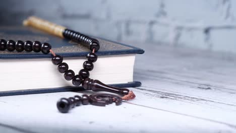 libro sagrado corán y cuentas de oración en la mesa, cerca.