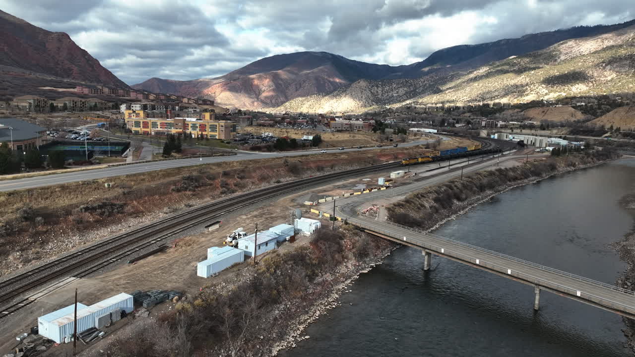 Drone ruota su un fiume, verso un treno, parzialmente, giornata di sole a Glenwood Springs