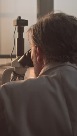 scientist looking through a microscope